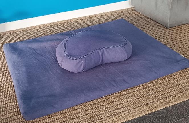 Zabuton e cuscino da meditazione appoggiati a terra, pronti per sedersi e meditare